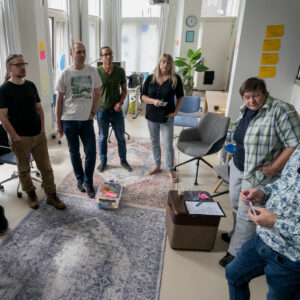 Een groepje medewerkers van TrailBlazers staand in overleg tijdens een TrailBlazers-kwartaalmeeting op 20/8/2024.